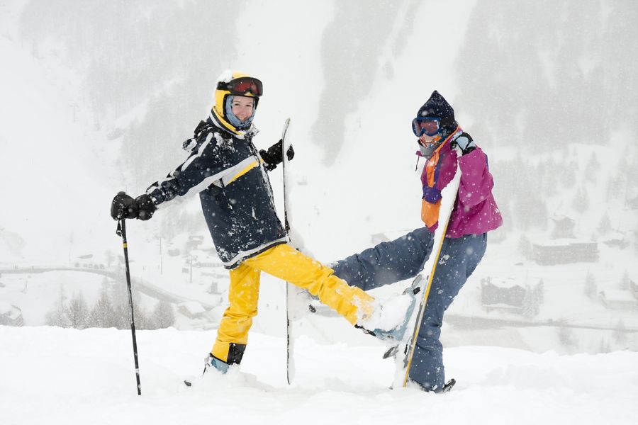 Happy young female skiers in the falling snow