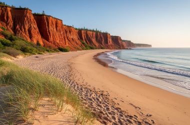Golden hour panoramic view of Prince Edward Island National Park’s red sandstone cliffs, dunes, and Atlantic beach along the north shore.